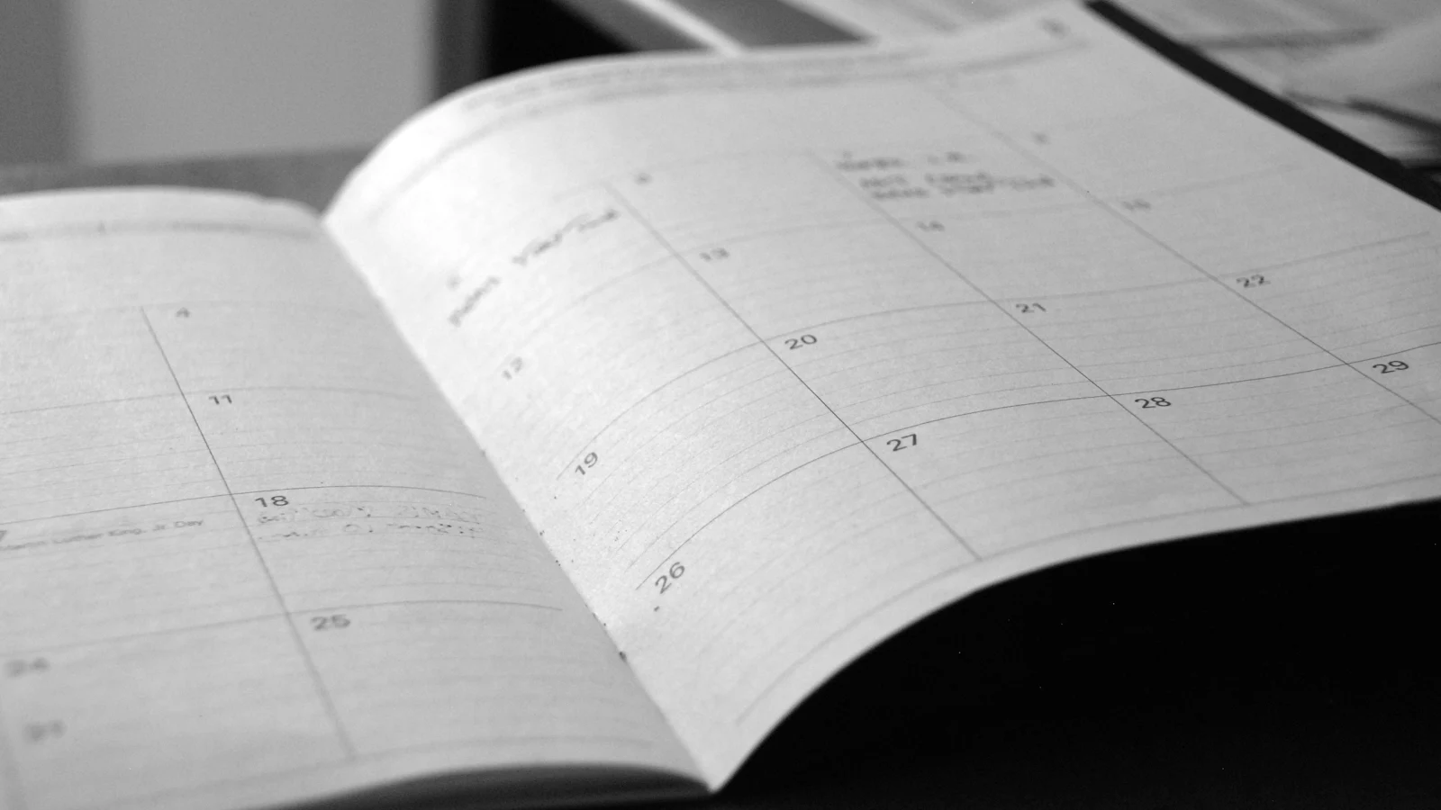 Una agenda mensual abierta sobre un escritorio.