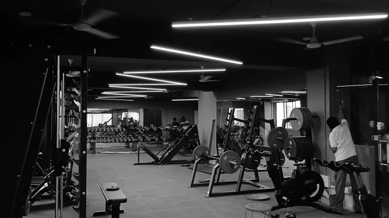 Interior de un gimnasio con máquinas y equipo de ejercicio.