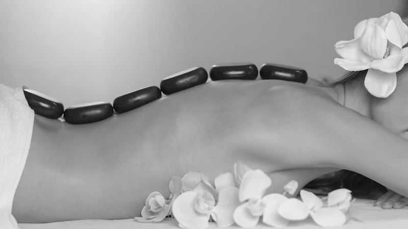 Una persona recibe un masaje con piedras calientes en un spa.